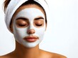 © CHAIYAPHON - A young woman with eyes closed relaxes while applying a luxurious white facial mask for skincare treatment.