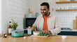 © Postmodern Studio - Young asian male preparing a healthy meal in a modern kitchen