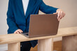 © Sergey - Elderly woman working on a laptop at a modern desk in a bright indoor space.