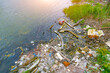 © aapsky - Garbage dumping at mouth river. Waste and plastic debris clutter the water surface near riverbanks, highlighting urgent issues related to water pollution environmental sustainability in urban areas