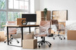 © Pixel-Shot - Interior of modern office with chairs wrapped in stretch film and cardboard boxes on moving day