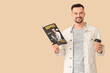 © Pixel-Shot - Handsome man with coffee cup reading magazine on beige background