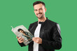 © Pixel-Shot - Handsome man reading magazine on green background