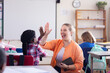 © wavebreak3 - High-fiving african american girl in classroom, female teacher celebrating achievement in school