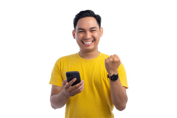 Portrait of excited handsome Asian man using smartphone, gesturing yes with clenched fist, celebrating good news isolated on transparent background