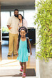 © Wavebreak Media - Smiling girl with backpack leaving home, Happy parents waving goodbye in doorway