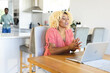 © Wavebreak Media - African American woman video chatting on laptop at home, smiling and engaged, copy space