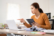 © Fahng - Asian business woman using digital tablet and laptop computer, working at home office. Female student studying online via tablet and laptop computer, reading e-book mobile app, internet technology