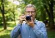 © JARVIS X - Smiling Photographer with Camera in Park Hobby, Nature Photography, Outdoor Portrait.