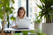 © PRASANNAPIX - young beautiful woman using laptop at eco friendly office