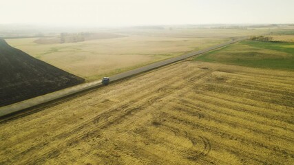 Wall Mural - Vehicle On Journey In The Road Passing Agricultural Lands At Sunrise. Aerial Drone Shot