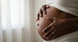 © julia - A pregnant woman tenderly hugs her belly on a gray background. The concept of preparing women for pregnancy, childbirth, motherhood.