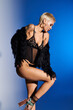 © LIGHTFIELD STUDIOS - Stylish young woman showcases modern fashion in striking studio setting with artistic lighting