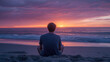 © Holaa - Person meditates on a beach at sunset with pink and purple sky and ocean waves in the background