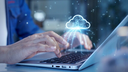 Leinwandbilder - Close-up of hands typing on a laptop with a digital cloud icon overlay, representing cloud computing, data storage, and online connectivity.