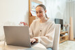 © ArinaDvl - Young woman working with laptop at home. Concept of remote work, education, and digital communication. Flexible hybrid work and learning conditions, freelance work.