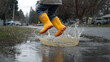 © ABX - Child splashing in a puddle with rain boots mid-air