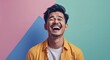 © sevenSkies - Indonesian 20s man on colorful plain bright background happy laughing hysterical looking at camera portrait banner with copy space ad concept marketing