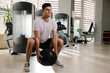 © New Africa - Muscular man exercising with medicine ball in gym