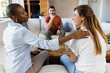 © Wavebreak Media - African American woman comforting friend on couch while man listens attentively, at home