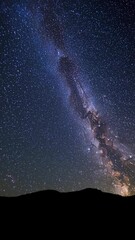 Wall Mural - a stunning wide-angle video capture of the milky way galaxy over a silhouetted landscape, showcasing