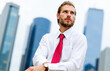 © Minerva Studio - Businessman looking up with folded arms in New York City
