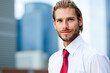 © Minerva Studio - Businessman smiling in front of skyscrapers, wearing red tie and white shirt