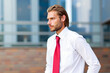 © Minerva Studio - Businessman wearing red tie standing near office building
