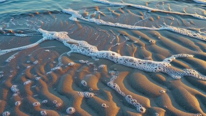 Wall Mural - a close-up view of a wave crashing on the beach, with water and sand in motion