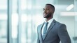 © NovaVision - A well-dressed, African American businessman in a suit looks towards a bright future with hope.