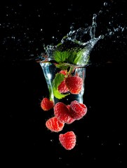 Fototapete -  Raspberries in water droplets against black background.