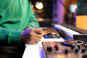 Aufkleber - Songwriter taking notes on paper to compose a new soundtrack, making rhymes and mixing musical elements together. Artist composer creating new verses for a song in home studio. Close up.