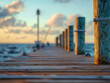 © MasTPX - A tranquil sunrise paints the sky as a wooden dock extends into calm ocean waters with weathered pilings and nautical rope adding a touch of seaside charm to this peaceful scene.