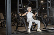 © JackF - Motivated fit senior woman using chest press machine in gym, staying active and maintaining physical strength through regular workouts..