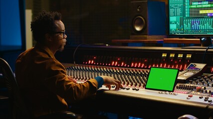 Leinwandbilder - Sound engineer expert recording audio tracks next to tablet mockup, adding sound effects on songs with mixing console. Producer pressing buttons and sliders in control room. Camera A.