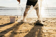 © ADDICTIVE STOCK - Fisherman collecting catch in net on sandy beach