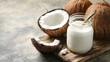 © Erika - un fondo con un frasco de leche de coco fresca saludable y vegana organica con cocos frescos comida nutricional refrescante tropical para el verano