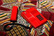 © Westend61 - Vintage red telephone on a colorful patterned surface representing nostalgia and communication