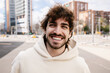 © Xavier Lorenzo - Portrait of young happy man smiling at camera standing at city street. Youth and people concept
