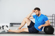 © New Africa - Athletic man with medicine ball resting on mat in modern gym