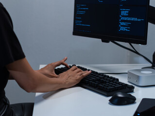 back view shot of latin female programmer and software developer working on desktop computer writing
