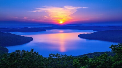 Wall Mural - Serene sunset over calm lake surrounded by lush green forest and distant mountains creating a peaceful and scenic landscape with vibrant colors
