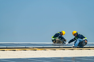 Wall Mural - two engineers install solar panels on a rooftop, wearing safety gear and helmets. the scene showcase