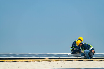 Wall Mural - two engineers install solar panels on a rooftop, wearing safety gear and helmets. the scene showcase