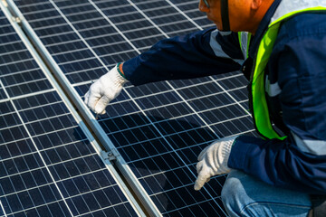 Wall Mural - two engineers install solar panels on a rooftop, wearing safety gear and helmets. the scene showcase