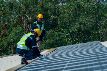 Wall Mural - two engineers install solar panels on a rooftop, wearing safety gear and helmets. the scene showcase