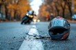 © Michael - Scratched motorcycle helmet and debris on asphalt, with blurred motorcycle in background, suggesting road accident