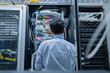 © reewungjunerr - Computer engineer is setting up network in server room,Systems Maintenance Technician,Male engineer working in server room at modern data center