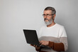 © New Africa - Mature man with laptop on light grey background