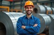 © miss irine - Smiling worker portrait in galvanized steel factory. Man in blue uniform orange helmet, arms crossed. Happy engineer, metal coils background. Steel production, heavy industry job.